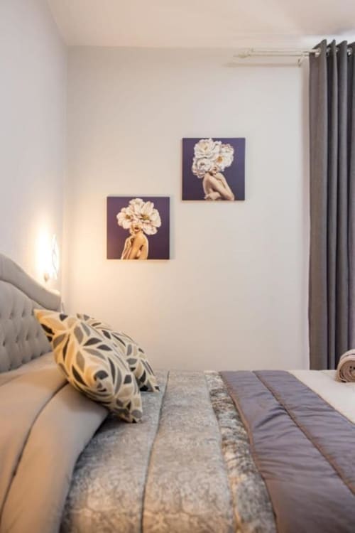 Camera moderna a La Maison Du Lion con quadri floreali bianchi, cuscino patterned e tende grigie a La Spezia