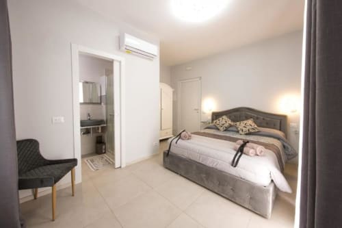 Moderna camera matrimoniale a La Maison Du Lion, La Spezia con letto imbottito grigio, bagno privato, aria condizionata e piastrelle