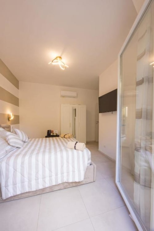 Camera matrimoniale moderna e luminosa a La Maison Du Lion B&B a La Spezia, con letto a righe e bagno privato