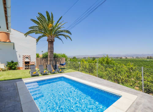 Villa de lujo con piscina, palmera, tumbonas y vistas a las montañas en Alhaurín de la Torre, España