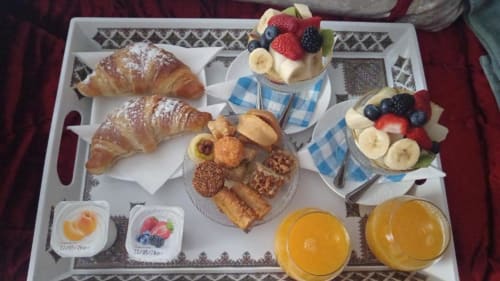 Vassoio colazione a La Maison du Lion con cornetti, crostate di frutta, pasticcini, frutti di bosco freschi, fette di banana e succo d'arancia