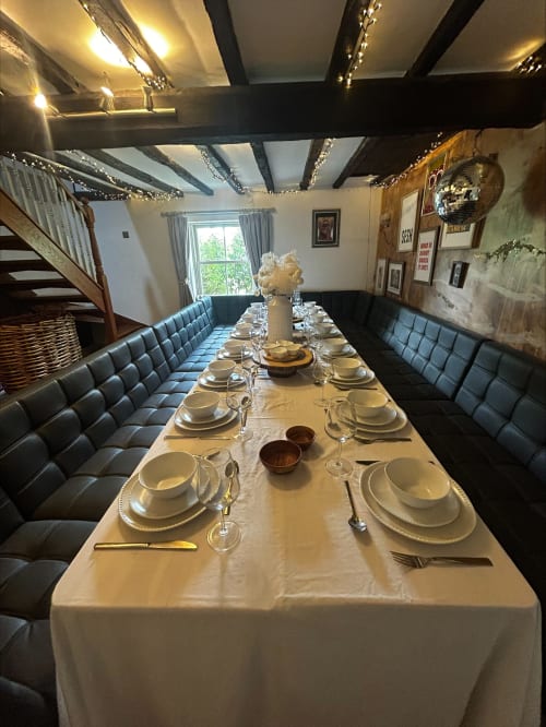Elegant formal dining room at The Lavender House with long table, white linens, place settings, and black upholstered