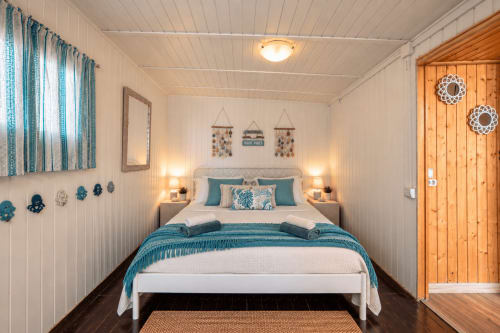 Accogliente camera da letto presso Sara & Gino Fuerteventura a Corralejo con accenti teal, pareti bianche, porta in legno e illuminazione calda