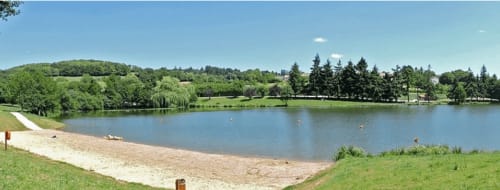 Plage de sable et lac tranquille à la maison d'hôtes Le Petit Moulin à Pouzauges, entourés d'arbres verts et de campagne