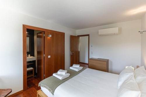 Quarto duplo espaçoso na Quinta Trindade com portas de madeira, roupa de cama branca, vista de montanha, ar condicionado e casa de banho privada