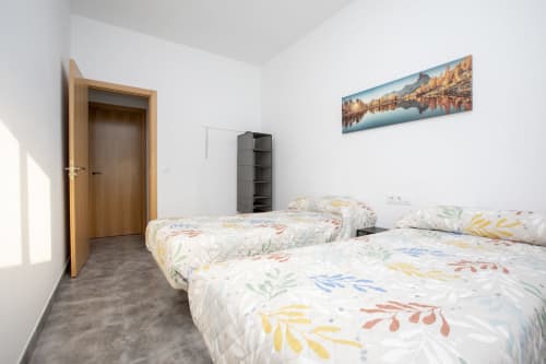 Luminosa habitación con dos camas de ropa de cama floral colorida en Hostal Restaurante Atalaya, Minas de Riotinto, España