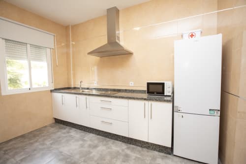 Cocina moderna en apartamento de 2 dormitorios en Hostal Restaurante Atalaya, Minas de Riotinto, con gabinetes blancos y acero inoxidable