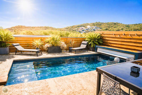 Piscine chauffée de la villa Core di Favona avec transats, terrasse en bois et vue sur les collines