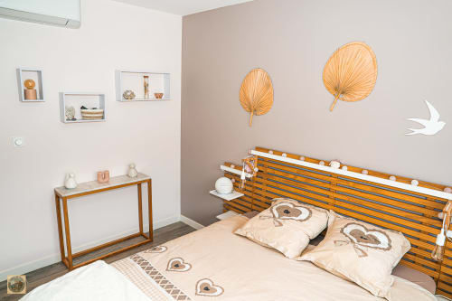 Chambre cosy de la Villa Core di Favona, Corse avec lit en bois, décoration murale en feuilles, étagères et literie beige