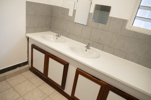 Salle de bains moderne avec double vasque et plan de travail blanc à l'appartement NGAYABE 976 à Mamoudzou, Mayotte