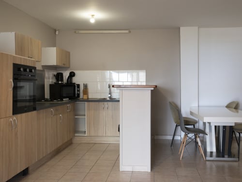 Cuisine moderne et séjour de l'appartement CP204 à NGAYABE 976, Mamoudzou avec meubles en bois et vue sur mer