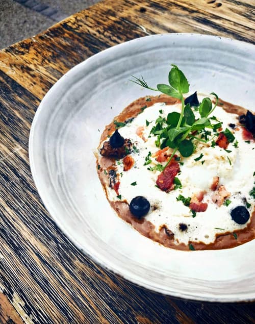 Pizza gourmande aux lardons, myrtilles, crème fraîche et herbes au restaurant Clos De La Gourmandière à Saint-Lothain
