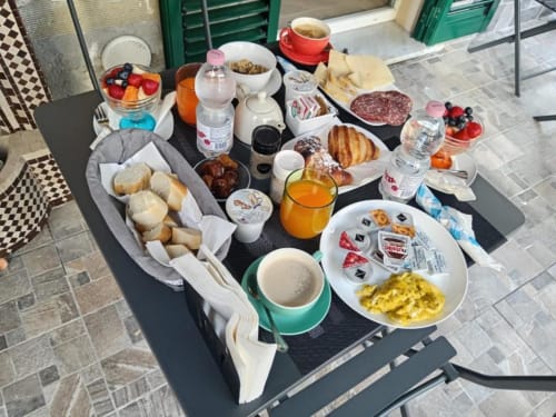 Colazione a La Maison Du Lion B&B a La Spezia: pasticcini, frutta fresca, formaggi, salumi e bevande.