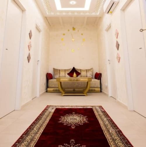 Corridoio della suite lusso a La Maison Du Lion B&B a La Spezia con divano dorato, dettagli rossi e tappeto ornamentale