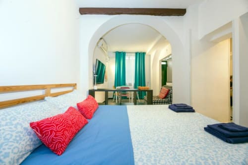Camera luminosa del La Superba Stay Genova con letti gemelli, zona living, tende turchesi e arredamenti moderni