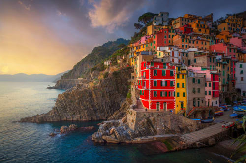 Il suggestivo villaggio di La Spezia con coloratissime case affacciate sulle acque turchesi del Mediterraneo al tramonto