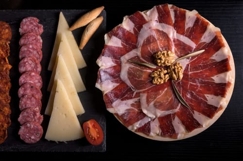 Tabla de quesos y embutidos españoles en A Casiña D'Avoa con jamón, queso, palitos de pan y nueces