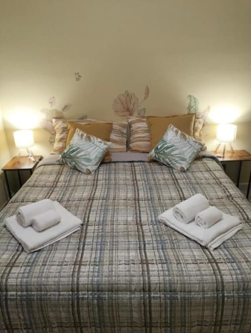 Camera TerraMia presso Affittacamere Rozzano B&B con letto matrimoniale, biancheria a tema tropicale, asciugamani freschi e lampade comodino