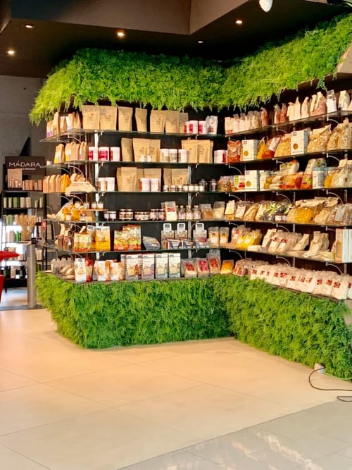 Épicerie de l'auberge Yasi Lyon avec murs végétaux artificiels et rayons d'aliments emballés