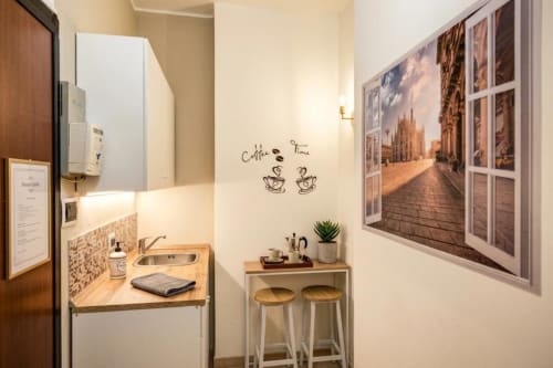 Accogliente zona cucina nel cottage Casa Giulia di Affittacamere Rozzano con bar caffè, tavolo da pranzo e quadri con vista sulla città