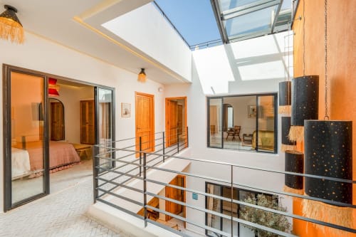 Chambre moderne style loft aux Résidences M avec puits de lumière, portes en bois orange et garde-corps métalliques