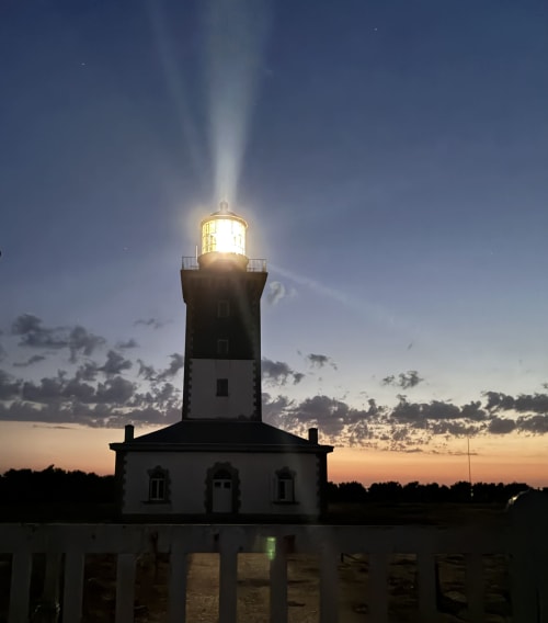 Phare au crépuscule avec faisceau lumineux, hôtel Ile et Villas Groix, Groix France