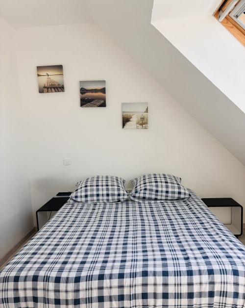Chambre avec literie à carreaux bleus et deux oreillers à la Villa Métisse d'Île et Villas Groix, villa bretonne avec trois encadrements