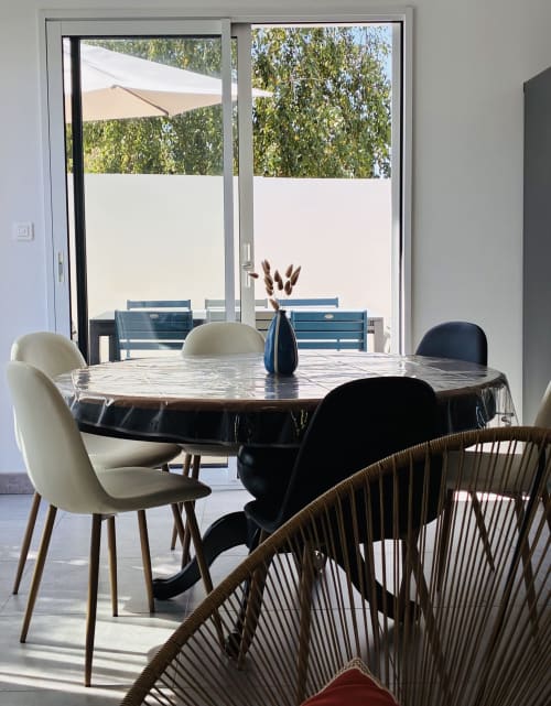 Salle à manger contemporaine à la Villa Métisse à Groix avec table en marbre, chaises design et vue sur la piscine de la terrasse