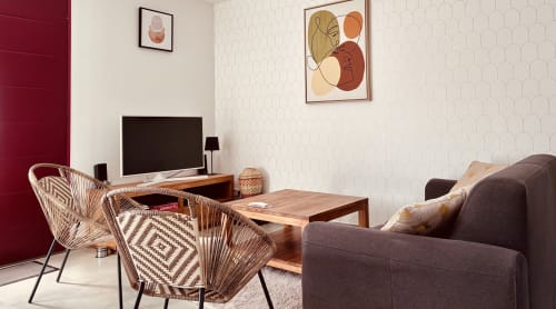 Séjour moderne à la Villa Garance avec fauteuils tressés, téléviseur écran plat, table en bois et vue mer chez Île et Villas