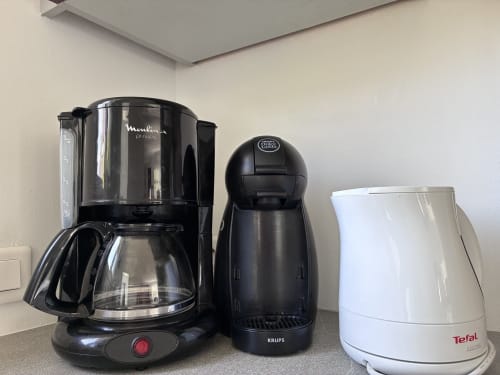 Trois appareils électroménagers sur le comptoir : cafetière Moulinex, machine à capsules Krups et bouilloire électrique Tefal à la Villa