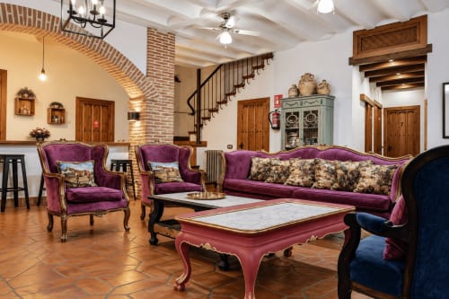 Elegante sala de estar con muebles de terciopelo púrpura en la posada El descanso del peregrino de Guadalupe, Cáceres