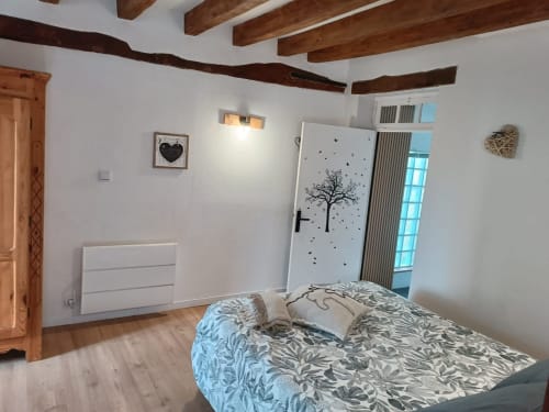 Chambre spacieuse à La Forge, La Maréchalerie à Lion en Sullias, avec poutres apparentes, vue sur jardin et équipements modernes