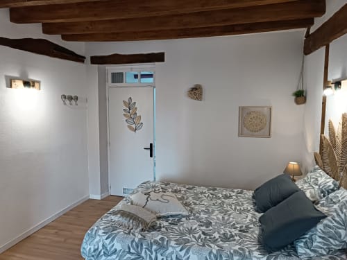 Chambre douillette à La Maréchalerie et le Nichoir à Lion-en-Sullias avec poutres apparentes, décor botanique et vue sur le jardin