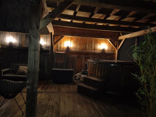 Intérieur rustique de cabane en bois la nuit, éclairage chaleureux, poutres apparentes et décor jardin à La Maréchalerie, Lion en Sullias