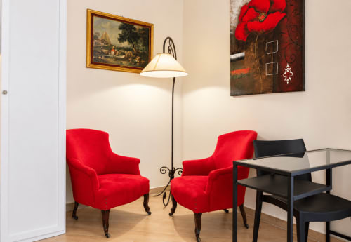 Red upholstered chairs and floor lamp in Sicily In Home apartment living room, Catania