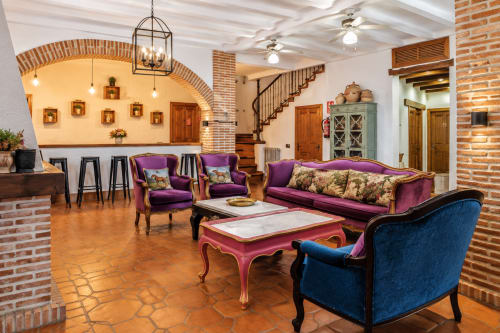 Sala de descanso del peregrino en Guadalupe con asientos de terciopelo púrpura, arcos de ladrillo y pisos de barro cocido