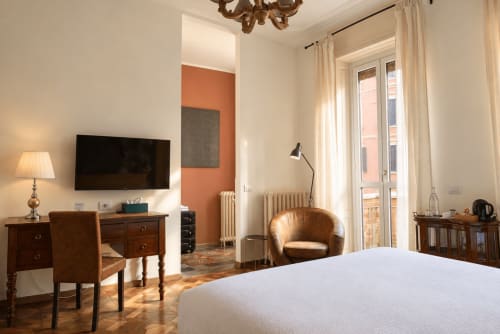 Camera superior Porta Tosa Milano con letto matrimoniale, TV a schermo piatto, poltrona in pelle e vista sulla città dal balcone