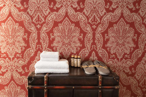 Valigia vintage con asciugamani bianchi, ciabatte e articoli da toilette presso la guest house Porta Tosa Milano