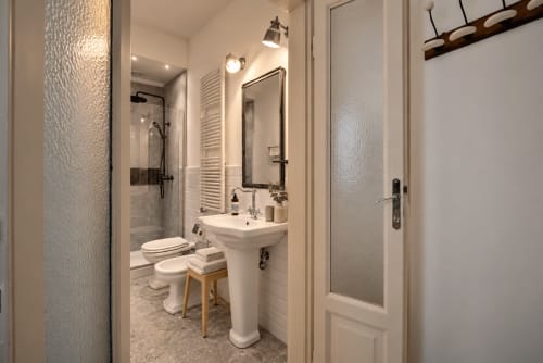 Bagno moderno a Porta Tosa Milano con lavabo su colonna, doccia, wc e illuminazione dello specchio
