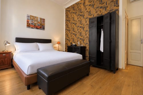 Camera moderna a Porta Tosa Milano con letto queen size, armadio nero, parete a motivi e pavimento in legno