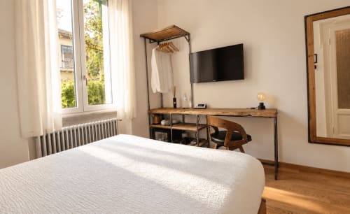 Piccola camera doppia presso Porta Tosa Milano B&B con TV a schermo piatto, scrivania, portaabiti e vista sul giardino dalla finestra