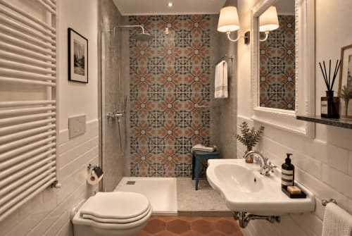 Bagno moderno a Porta Tosa Milano B&B con doccia a piastrelle decorate, lavandino bianco, wc, scaldasalviette e illuminazione ambientale