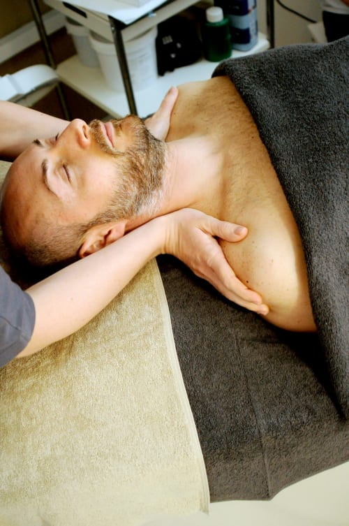 Thérapeute pratiquant un massage du cou à un client au spa bien-être Domaine Du Commandeur à Mondragon