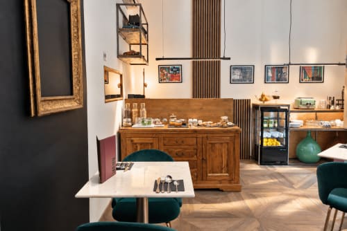 Showroom Porta Tosa Milano con stoviglie, mobili in legno e sedute in velluto turchese in una boutique italiana moderna