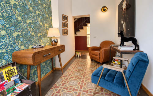 Lobby della boutique hotel Porta Tosa a Milano con carta da parati blu decorata, arredamento in legno retrò e sedie in velluto blu