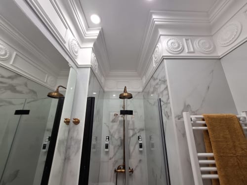 Luxury marble bathroom with dual rainfall showers, bronze fixtures, and ornate ceiling details at Salamanca Madrid hotel