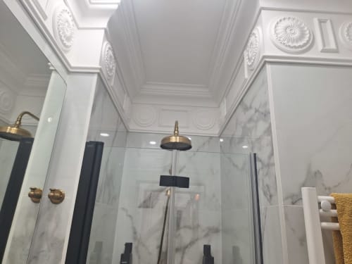 Luxury bathroom with marble tiles, brass fixtures, and ornate ceiling details at Salamanca Luxury Rooms, Madrid