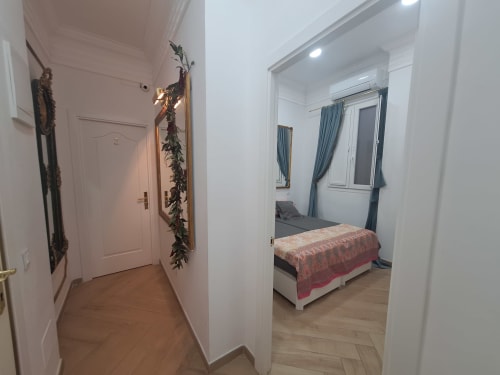 Modern hallway at Salamanca Luxury Rooms Madrid leading to spacious bedroom with bed and blue curtains