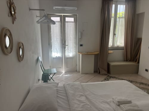 Luminoso studio San Gottardo a Milano Lovelyloft con letto bianco, porte in vetro, climatizzatore e arredamento minimalista moderno