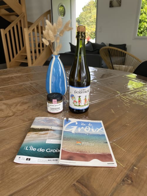 Table à manger à la villa Île et Villas Groix avec guides touristiques locaux, rillettes de sardine et bouteille de Cidre Fermier